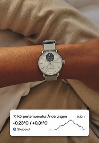 Silberne Smartwatch mit rundem Ziffernblatt, weißem Zifferblatt und grauem Armband. Zeigt Temperaturänderungen und ein Liniendiagramm an. Die angezeigte Uhrzeit ist 9:32.
