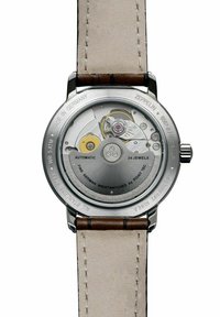 Stainless steel watch back with automatic movement, featuring visible gears and 24 jewels. Leather strap in beige with brown accents.