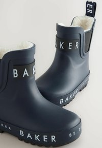 Bottes en caoutchouc marine avec marquage blanc 'BAKER', doublure en peluche, panneaux élastiques sur les côtés et semelles texturées pour une meilleure adhérence.  Orteils ronds et hauteur cheville.