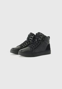 Black mid-top sneakers with a textured leather upper, lace-up and side zipper closure, rubber outsole, and subtle logo detail on the side.