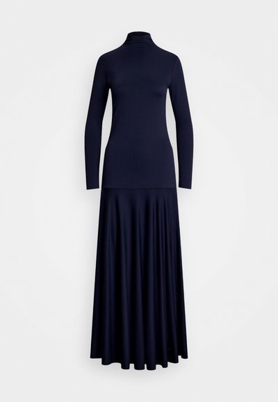 Μπλε φόρεμα μακρυμάνικο με ρολό λαιμό και ρεύστη φούστα maxi. Το ύφασμα φαίνεται λείο με εφαρμοστό μπούστο που μεταβαίνει σε φαρδύ στρίφωμα.