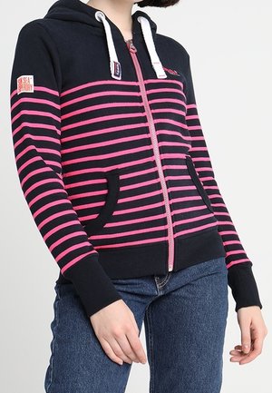 Marineblauwe rits-hoodie met roze horizontale strepen, verstelbare capuchon en twee voorzakken. Heeft ribgebreide manchetten en onderrand.