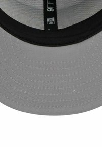 Cappellino da baseball grigio con visiera arrotondata, dettagli neri sulla visiera, e texture tessile. Etichetta interna con la scritta "9FIFTY".