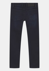 Mörkblå denimjeans med slim fit. Har två bakfickor med en diskret design och en texturerad midja.