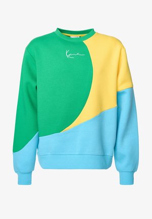 Bluza z blokami kolorów w odcieniach zieleni, żółci i niebieskiego. Wykonana z miękkiego materiału, posiada okrągły dekolt i prążkowane mankiety. Zawiera charakterystyczny detal.