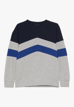 Langærmet sweater med rund hals, mørkeblå øverste del, lysegrå nederste del og en blå chevronstribe over brystet og ærmerne.