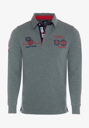 Pitkähihaisen polo-paidan harmaa puuvilla, jossa on punainen ja laivastonsininen kaulus. Varustettu brodeeratuilla logoilla ja teksteillä, kauluksessa kaksi nappia.