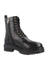 Botas de tobillo de cuero negro con ojales dorados, parte delantera con cordones, cremallera lateral y suela de goma gruesa; textura suave y diseño robusto.
