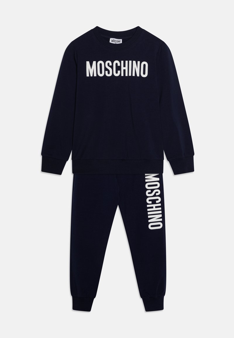 Tamno plavi pamučni trenirka s dugim rukavima i elastičnim manžetama, s "MOSCHINO" logom u bijeloj boji na gornjem dijelu i hlačama.