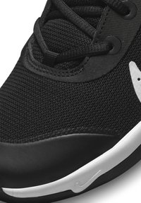 Black athletic shoe with textured fabric upper, black laces, and a white sole. Also features a white logo accent on the side.