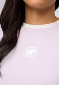 Lichtpaarse kortekl shirt met een ronde halslijn, voorzien van een witte cartoonmammoetlogo op de borst. Zachte stoftextuur.