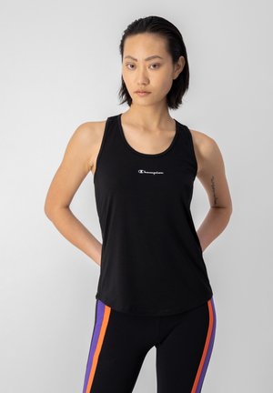 Top deportivo negro sin mangas con escote redondo y logo en el pecho. La tela parece suave y ajustada, combinada con leggings multicolores.