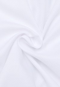 Witte gestructureerde stof met een diamantvormig patroon, licht doorschijnend, zacht aanvoelend en in een draaiende beweging gedrapeerd.