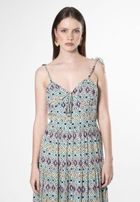 Maxi-jurk met een kleurrijk geometrisch patroon in tinten blauw, roze en geel. Spaghetti-bandjes en een cinched taille detail.