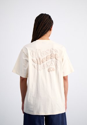 Beige cotton t-shirt featuring a textured, embossed logo design on the back. Short sleeves, loose fit, and simple crew neckline.