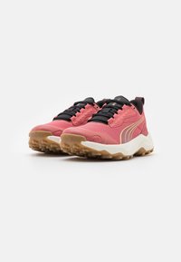 Zapatillas deportivas rosas con cordones negros, parte superior texturizada y una media suela blanca. Presentan una suela de goma resistente para mayor tracción.