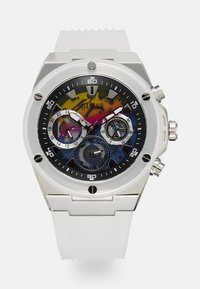 Reloj de bolsillo de caja plateada redonda con un dial abstracto multicolor. Presenta una correa de silicona blanca, sub-diales visibles y un bisel negro con acentos plateados.