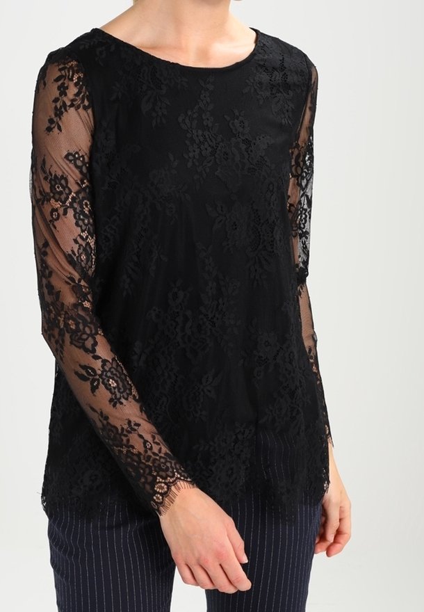 Top in pizzo nero con maniche lunghe trasparenti, motivo floreale, scollatura rotonda e vestibilità comoda, abbinato a pantaloni navy a righe sottili.