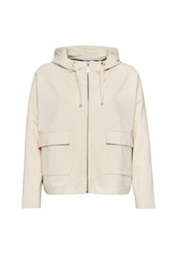 Jasno beżowa bluza z kapturem na zamek, wykonana z miękkiego materiału, z kapturem ze sznurkiem, dwoma przednimi kieszeniami oraz luźnym krojem z opuszczonymi ramionami.