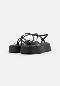 Svarte plattformsandaler med flere tynne stropper og en elegant, glatt overdel. Sålen er kraftig med en teksturert finish.