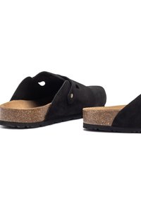 Zwarte suede sandalen met kurken voetbed, open teen ontwerp, en een getextureerde rubberen zool. Voorzien van een decoratieve metalen knoopaccent.