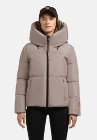 Pufferjakke i blød beige med en oversized h�ætte, frontlynlås og to sidelommer. Har elastiske manchetter og subtil branding på ærmet.
