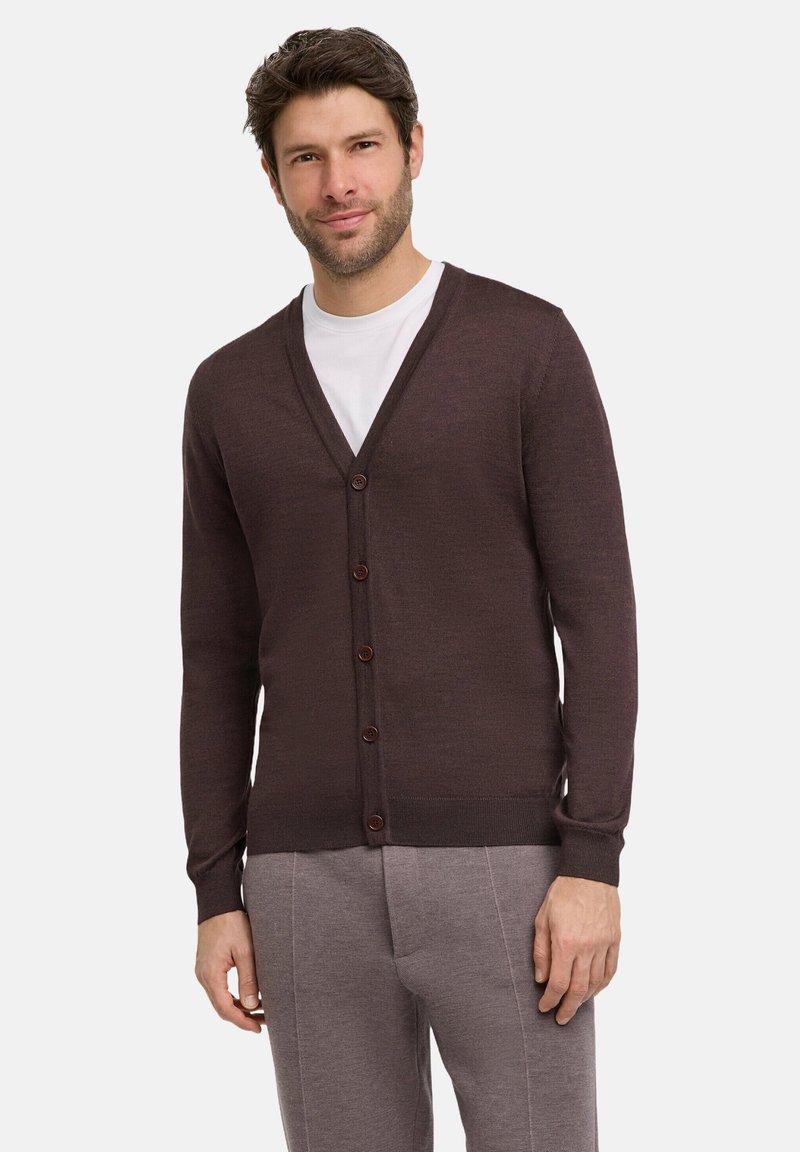 Dunkelbrauner Cardigan mit V-Ausschnitt, sieben Knöpfen vorne, gerippten Bündchen und Saum, aus Strickstoff, kombiniert mit einem weißen T-Shirt.