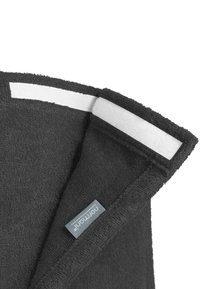 Dunkelgraues Handtuch mit strukturierter Oberfläche, ausgestattet mit einer weißen Stoffschlaufe und einem Etikett mit Markentext am unteren Rand.