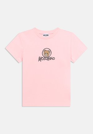 Ροζ ανοιχτό κοντομάνικο T-shirt με καφέ πρόσωπο αρκούδας και τη λέξη "Moschino" τυπωμένη με μαύρο στο κέντρο μπροστά.