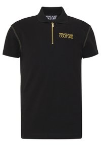 Zwarte poloshirt van katoen. Beschikt over korte mouwen, een ritskraag en een goud geborduurd "VERSACE JEANS COUTURE" logo op de borst.