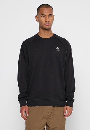 Black sweatshirt with a round neckline and raglan sleeves. It features a small white Adidas logo on the chest and a relaxed fit.