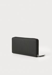 Čierna peňaženka na zips vyrobená z textúrovaného materiálu. Obdĺžnikový tvar s hladkým povrchom a striebornými akcentami. Kompaktný a elegantný dizajn.