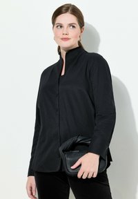 Zwarte button-up shirt met een mandarin kraag, lange mouwen en een gladde textuur, gecombineerd met een zwarte handtas met textuur.