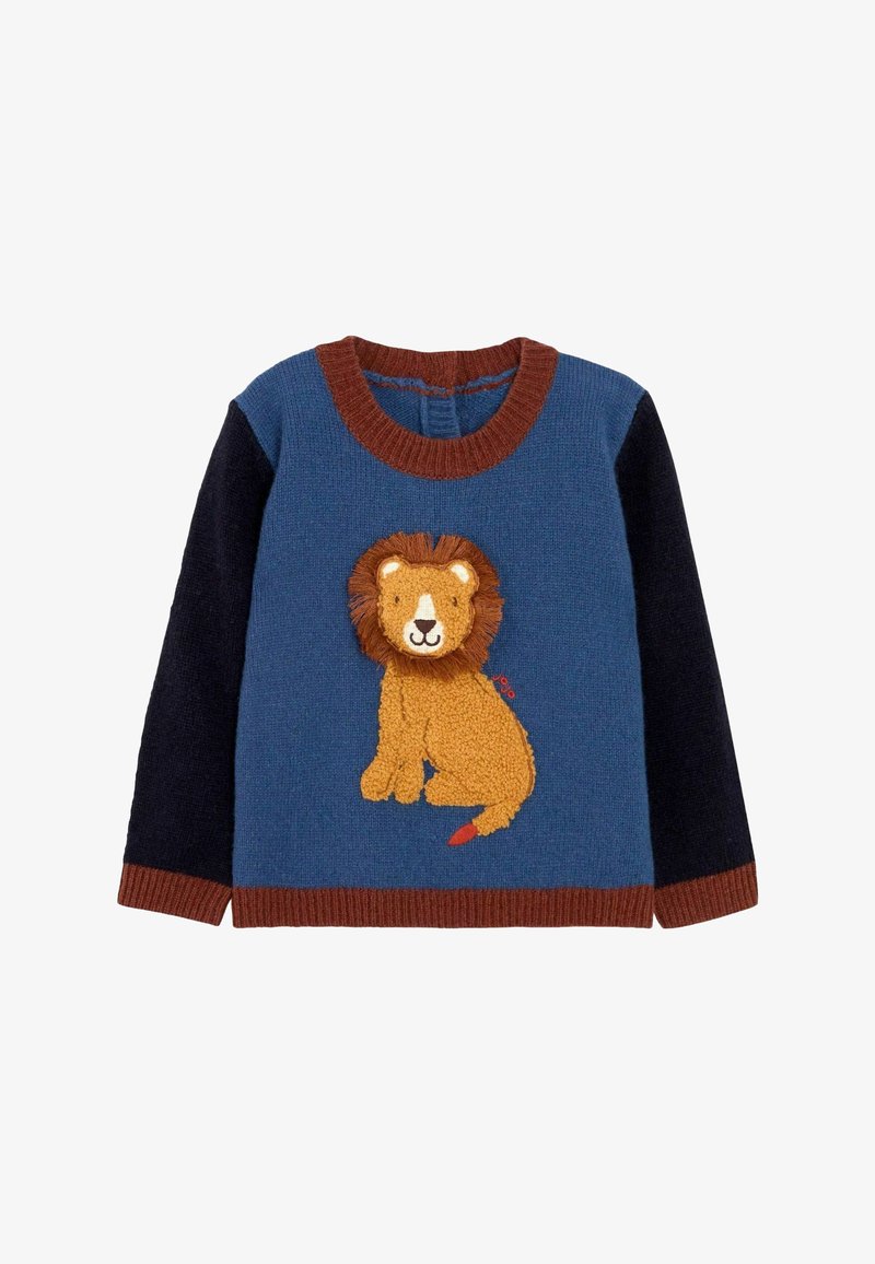 Neulepaita, jossa on leijonateema tekstuurisessa kultalangassa, sinisessä vartalossa ja tummansinisissä hihoissa. Ribbollinen ruskea kaula-aukko ja helma luovat kontrastia.