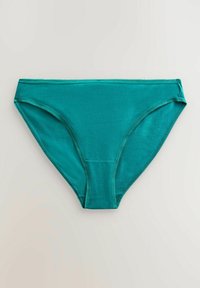 Teal bomullstrosor med slät textur, medelhög midja och sydda kanter. Inga synliga mönster eller metallaccenter.