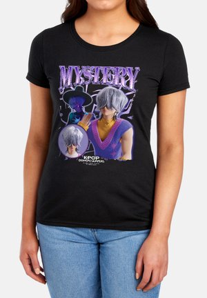 Woman wearing black tee with graphic of two characters with gray hair and hat, text "MYSTERY" and "K-POP DEMON HUNTERS" below.