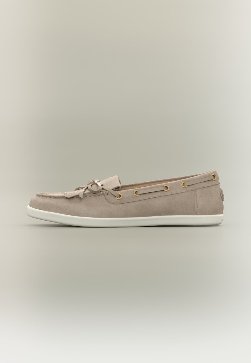 Mocassin en daim beige avec semelle en caoutchouc blanche, nœud décoratif et œillets dorés sur les côtés, vu en profil gauche.