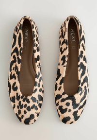 Ballerine con stampa a leopardato, in beige e nero, con una tomaia morbida e testurizzata, caratterizzate da una punta arrotondata e dettagli laterali a taglio.