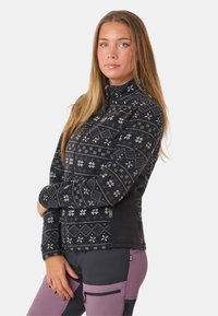 Czarna polarowa kurtka z geometrycznym wzorem płatków śniegu w kolorze białym. Zamek z przodu, wysoki kołnierz i dopasowany krój. Z dodatkową kieszenią.