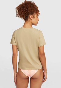 Short-sleeve beige t-shirt with a straight hem and crew neck, paired with pink patterned underwear, showing a smooth texture and simplified design.