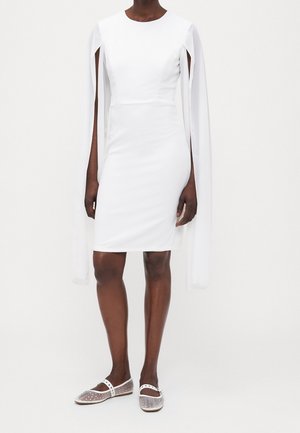 Bílé přiléhavé šaty s dlouhými průhlednými rukávy a kulatým výstřihem. Hladká textura a přiléhavý střih, vhodné k transparentním balerínkám s puntíky.