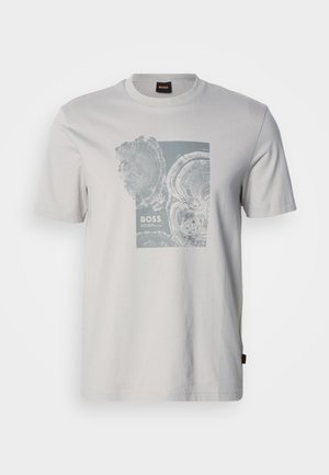 Svetlo siva majica kratkih rokavov s potiski krožnih lesenih obročev in besedilom "BOSS" na sredini spredaj.