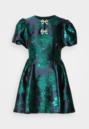 Vestido de cetim com mangas bufantes, base azul marinho, padrão floral verde vibrante, fecho frontal adornado. Cintura ajustada, saia godê.