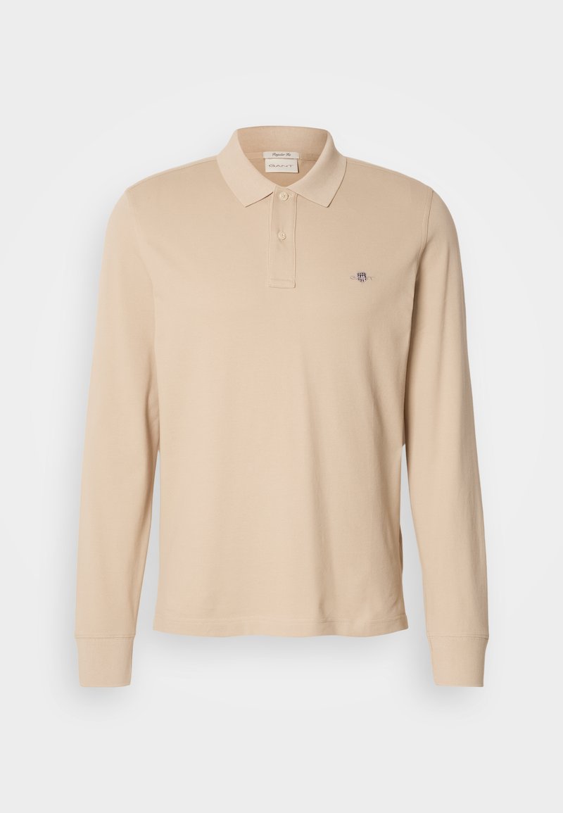 Beige Langarm-Polohemd aus weichem Stoff mit einem Kragen, zwei Knöpfen und einem kleinen gestickten Logo auf der Brust.