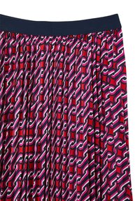 Gonna plissettata con un motivo geometrico multicolore in rosso, nero, bianco e viola. La vita è di un blu navy uniforme. Realizzata in tessuto morbido.