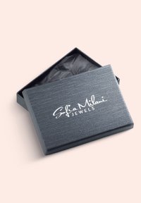 Grå tekstureret smykkeboks med en blød finish og hvidt trykt logo "Sofia Milani JEWELS." Låget er let åbent, hvilket afslører sort silkepapir indeni.