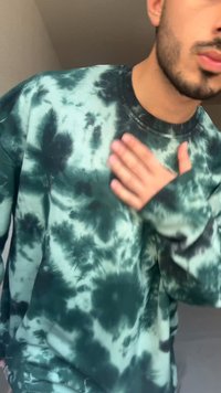 Zielona bluza tie-dye w różnych odcieniach, luźny krój, okrągły dekolt i długie rękawy, z miękką strukturą i wyraźnymi czarnymi wzorami.