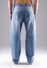 Hellblaue Denim-Jeans mit lockerer Passform, ausgestattet mit zwei Gesäßtaschen und einem Lederpatch am Bund. Mit einem verblassten Muster und geradem Bein-Design.