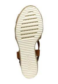 Suola di sandalo marrone con gomma bianca texturizzata, caratterizzata da perforazioni e scanalature, impressa con "GEOX". Design piatto con una forma della punta arrotondata.