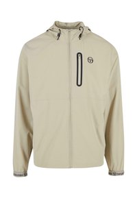 Beige větrovka s náprsní kapsou na zip, nastavitelnou kapucí a elastickými manžetami, na které je logo. Lehký materiál.